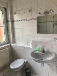 a bathroom with a sink and a toilet at Ferienwohnung Tapetenwechsel -Balkon- in Dresden