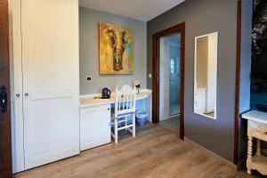 a kitchen with a desk and a painting on the wall at Posada Araceli in Santillana del Mar