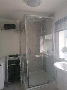 um chuveiro com uma porta de vidro na casa de banho em Chota Gher Apartment em Widnes