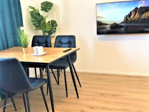 ein Esszimmer mit einem Tisch und 4 Stühlen in der Unterkunft 3Rooms Central-Modern- The Alps by SA-Grandeur in Friedrichshafen