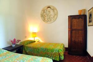 a room with two beds and a clock on the wall at La Villa di Caiano in Londa +31 photos