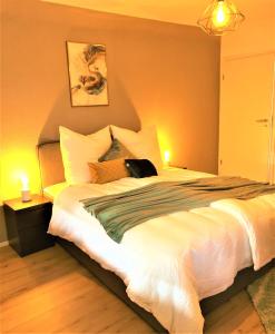 a bedroom with a large bed with a cat sitting on it at 3Rooms Central-Modern- The Alps by SA-Grandeur in Friedrichshafen