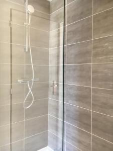 a shower with a glass door in a bathroom at Les Bains Boyardville - Hôtel et Restaurant in Boyard-Ville
