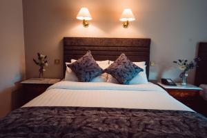 Un pat sau paturi într-o cameră la Greenway Manor Hotel