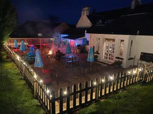 a fence with lights in front of a restaurant at night at The Castle Inn in Dirleton