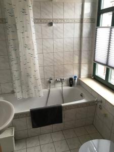 a bathroom with a tub and a sink and a toilet at Ferienwohnung Kurzmalweg -Balkon- in Meißen