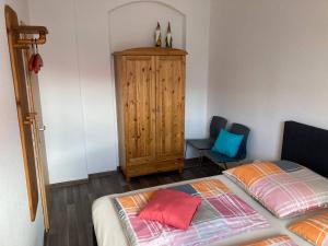 a bedroom with a bed and a wooden cabinet at Ferienwohnung Kurzmalweg -Balkon- in Meißen