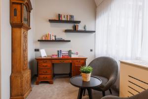 ein Zimmer mit einem Schreibtisch, einem Stuhl und einem Tisch in der Unterkunft Bilderberg Grand Hotel Wientjes in Zwolle