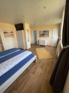 um quarto com uma cama grande e pisos em madeira em Achterkoje em Heiligenhafen