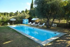 a swimming pool with chairs and umbrellas in a yard at La Villa di Caiano in Londa
