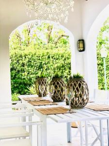 una mesa blanca con copas de vino y una lámpara de araña en Villa Leon Menorca, tu casa menorquina! en Cala'n Bosch