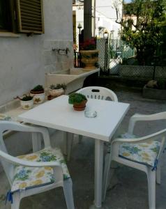 uma mesa branca e duas cadeiras com plantas em Alfi BeB em Le Torri