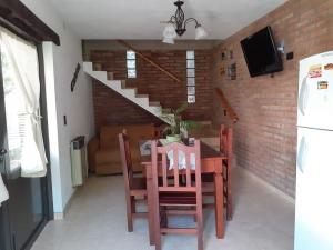 a dining room with a table and chairs and a staircase at Los algarrobos in Villa Carlos Paz