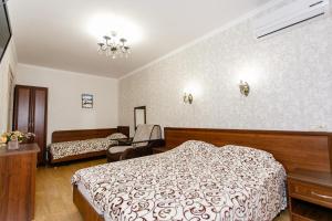 アナパにあるApartment on Verkhnyaya Doroga 151のベッドと椅子付きのホテルルーム