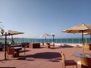 a patio with tables and chairs and umbrellas at Blue Sunset Flats Beira Mar - Apt 217 in João Pessoa