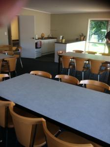 Un aula vacía con una mesa y sillas azules. en Chelmswood Motel Taupo, en Taupo 130 fotos más