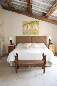 Saint-André-de-RoquepertuisにあるClarberg - Gîteのベッドルーム1室(ベッド1台付)が備わります。壁には絵画が飾られています。