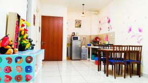 a kitchen with a table and chairs and a refrigerator at Mevin Woodsbury Suite Butterworth Penang in Butterworth