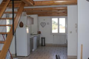 a kitchen with a refrigerator and a window at maly appart avec balcon et 1 studio en rez-de-chaussée in Vedène