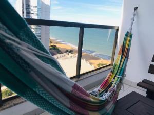 a hammock in a room with a view of the ocean at Praia Dourada in Vila Velha