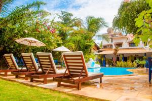 a group of lounge chairs and a swimming pool at Pousada Arriba Pipa in Pipa