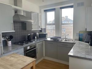 a kitchen with a sink and a stove top oven at Woolacombe Seaside Apartment in Woolacombe
