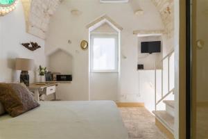 een slaapkamer met een bed, een raam en een bureau bij Chianca Antica in Ostuni