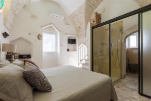 een slaapkamer met een bed en een inloopdouche bij Chianca Antica in Ostuni