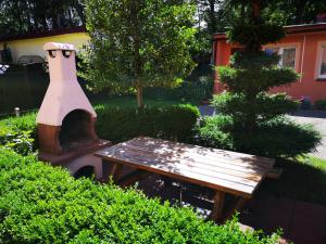 a wooden table and a bench in a garden at Wypoczynek Roda in Pobierowo