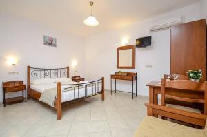 a bedroom with a bed and a table and a mirror at Asterias Studios in Agia Anna Naxos