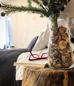 a vase filled with rocks and a book on a table at Lovely Home Marta in Pozzuoli