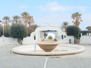 a large fountain in a courtyard with palm trees at Luxury Apartment with Sea View near Kallithea in Koskinou