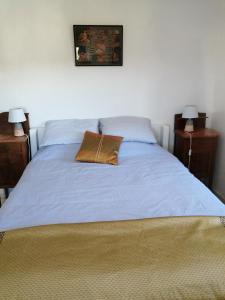 a bed with a blue blanket and two night stands at A Quinta da Colina ( Casinha ) in Castanheira de Pêra +20 photos