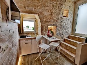 eine Küche mit Tisch und Stühlen in einem Zimmer in der Unterkunft Trully in Alberobello