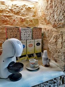 ein Tisch mit einer Kaffeemaschine und einer Tasse Kaffee in der Unterkunft Trully in Alberobello