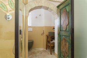 een badkamer met een toilet en een groene deur bij Chianca Antica in Ostuni +27 foto's