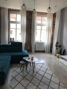a living room with a blue couch and a table at Apartament Paderewskiego 10 in Świnoujście