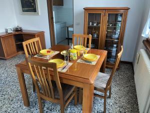 einen hölzernen Esstisch mit gelben Gerichten darauf in der Unterkunft Villino Carla in Lipomo
