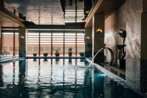 - une piscine dans un bâtiment avec de l'eau dans l'établissement Fabesca Boutique Hotel & SPA, à Sovata