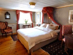 a bedroom with a large bed with a red canopy at Gripsholms Värdshus in Mariefred