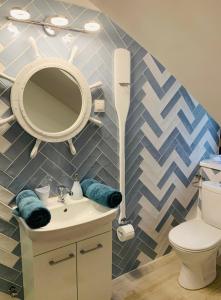 uma casa de banho com um lavatório, um espelho e um WC. em Szines Panoráma Apartman em Balatonlelle