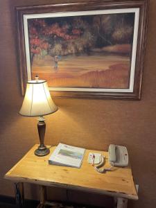 a table with a lamp and a picture on the wall at Elkwater Lake Lodge and Resort in Elkwater