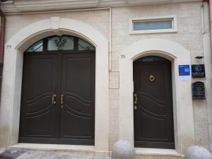 two black doors on the side of a building at La Luna e il Sole in Barletta