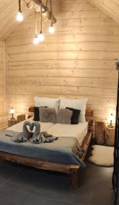 a bedroom with a bed in a wooden wall at Domek na wypoczynek in Tylicz