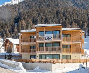 un edificio con el letrero de las llaves en la nieve en Residence Lex en Resia