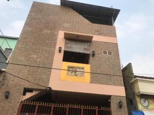 a tall brick building with a yellow door at KoolKost Syariah near Pelabuhan Tanjung Priok (Minimum Stay 6 Nights) in Jakarta