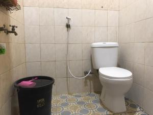 a bathroom with a toilet and a trash can at KoolKost Syariah near Pelabuhan Tanjung Priok (Minimum Stay 6 Nights) in Jakarta