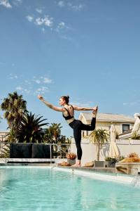 a woman is standing on the edge of a swimming pool at DysArt Boutique Hotel - Solar Power in Cape Town