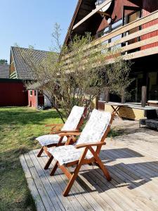 2 sillas de madera sentadas en una terraza de madera en Summers Paradise, en Åhus