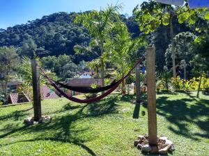 una hamaca en un campo con una montaña en el fondo en Chalé Vale da Mata, en Visconde De Maua